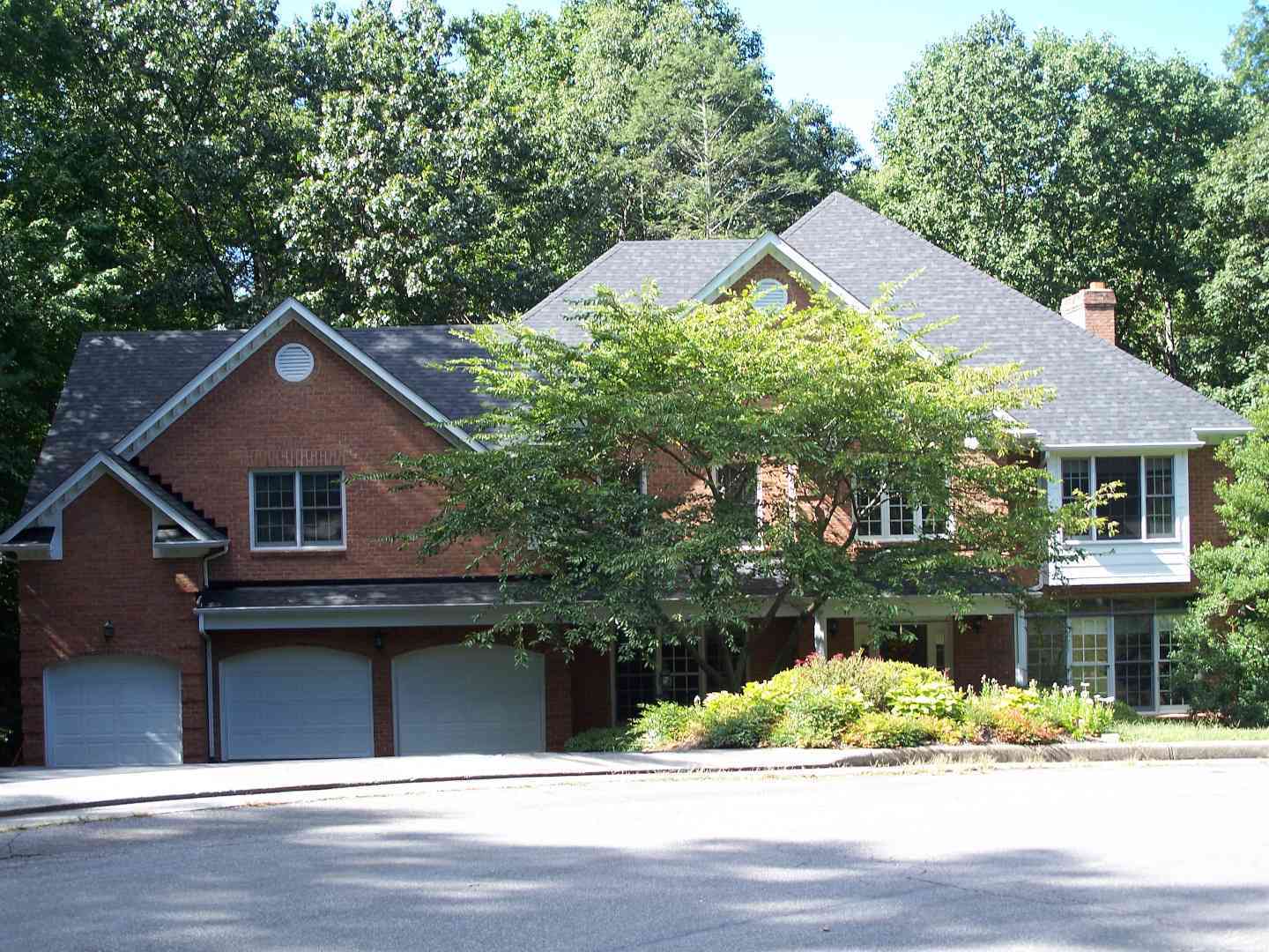 A single family home with a three car garage and gray roof