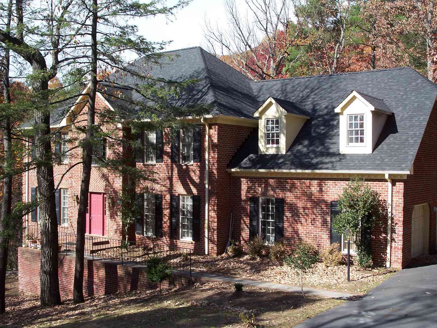 Brick home with a new roof matching the colors well.