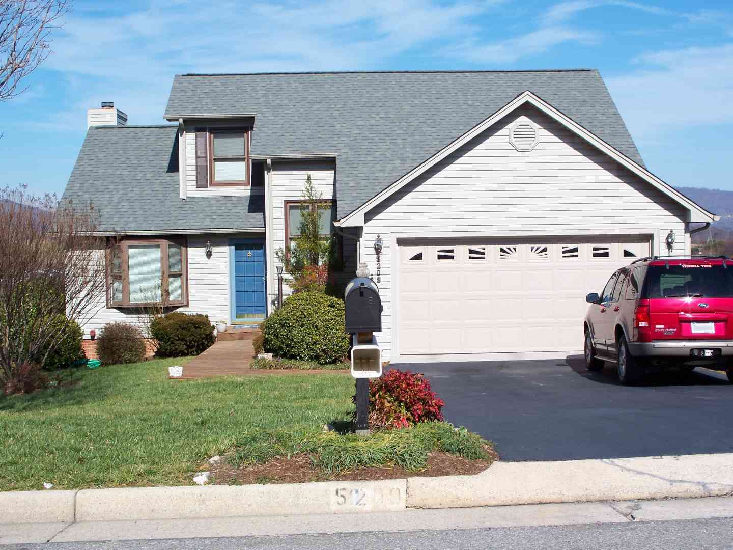 A home with a gray roof and moutains in the background